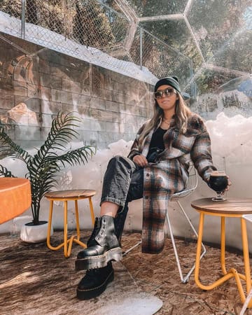 Woman drinking mulled wine in a dining pod in the winter