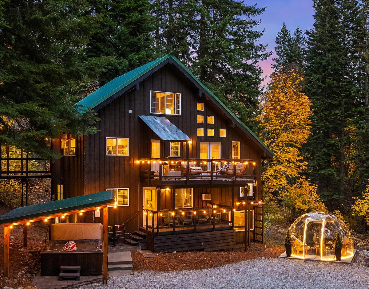 Cabin lodge with geodome in autumn evening with string lights