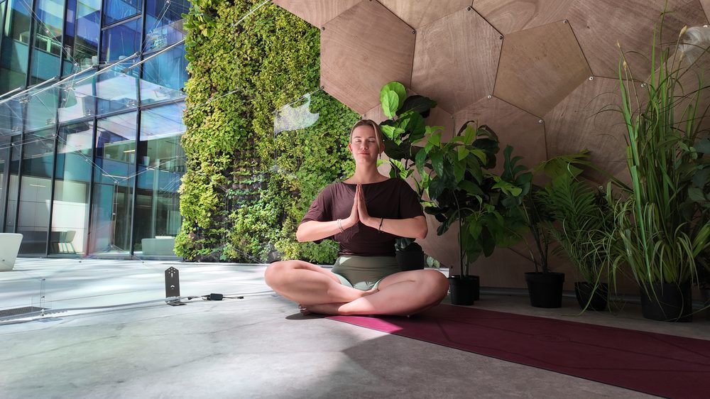 A person meditating in the dim, calm interior of a Wellness Dome with blackout curtains drawn