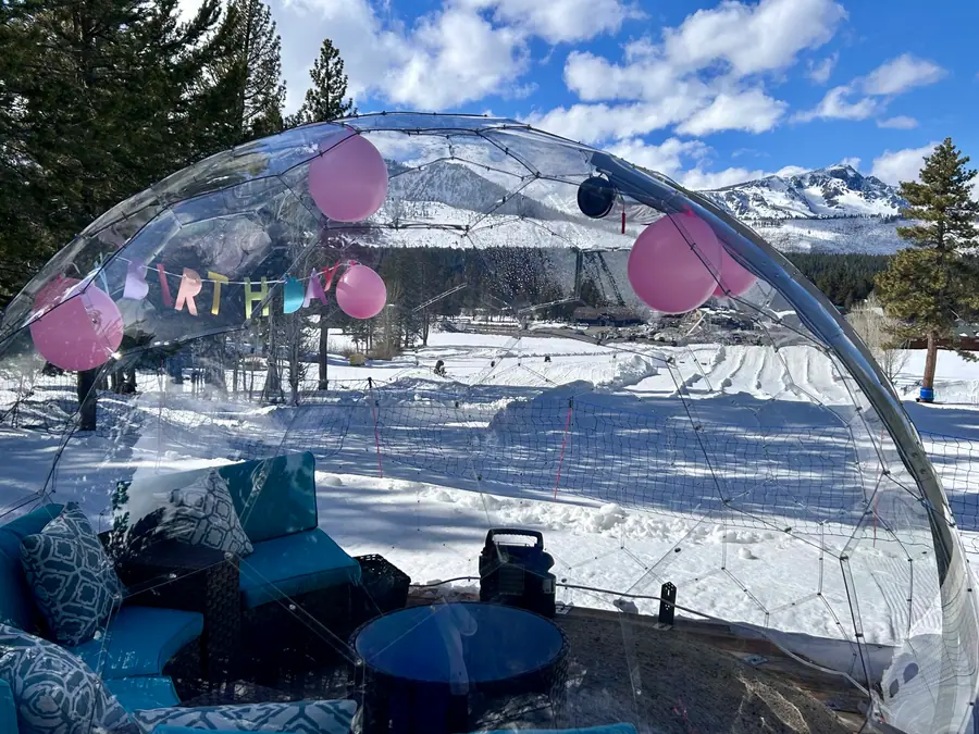 Dome decorated with balloons for a birthday party overlooking snowy mountains
