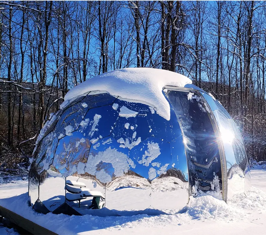 Mirror-finish dome with a heavy snow cap in a sunny winter forest