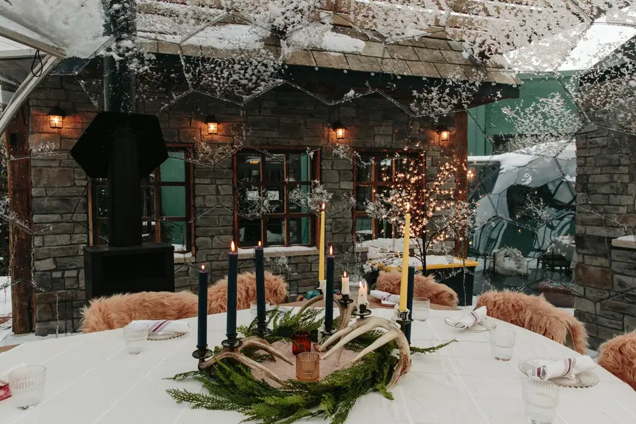 Snow-dusted mirror dome framing an elegant candlelit winter table