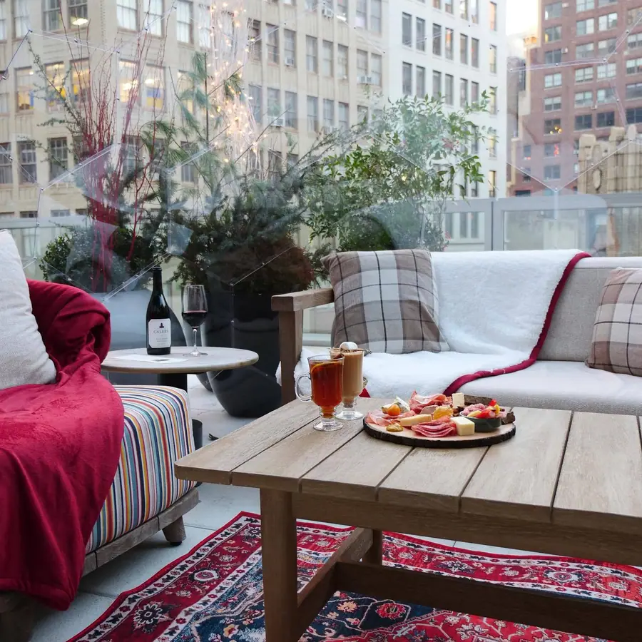 Rooftop dome lounge with plaid cushions, charcuterie and hot drinks