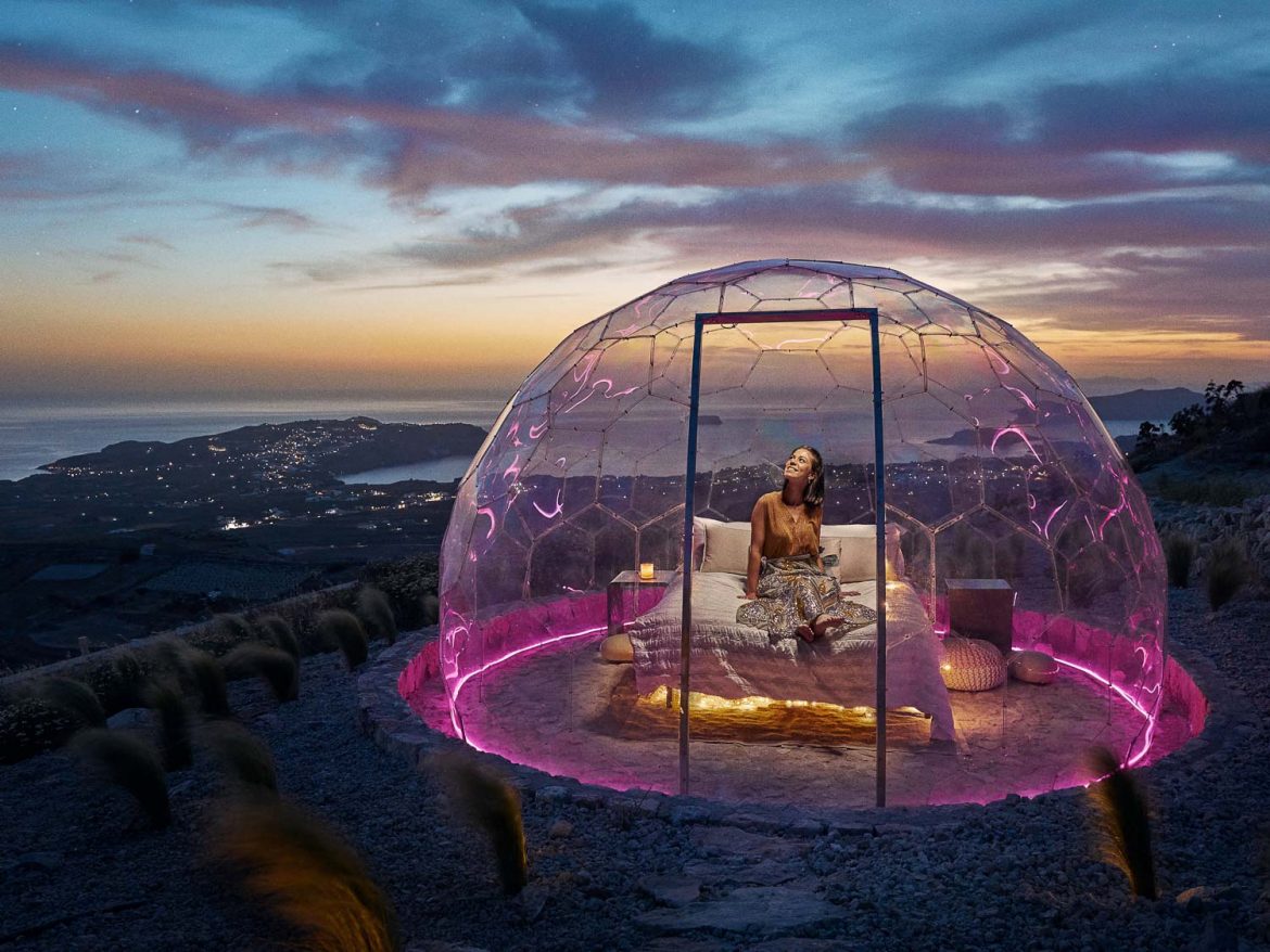 Frau sitzt in einem klaren Hypedome S in der Abenddämmerung