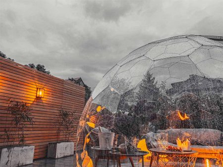 Illuminated clear garden dome in the rain