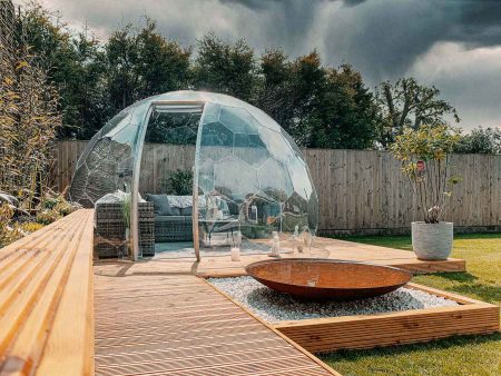 Clear garden dome on a patio with a set of lounge furniture