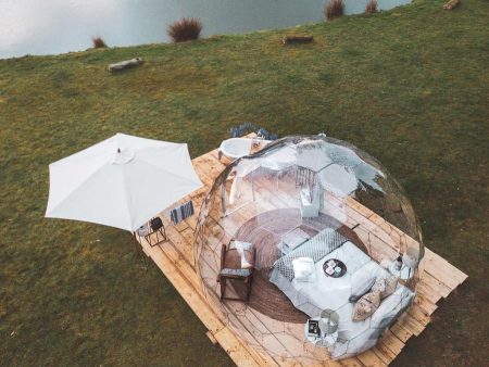 See-through glamping dome with bed by the lake