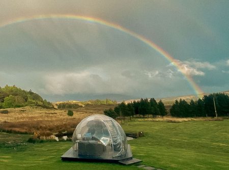 A geodesic dome in a humid area with a rainbow