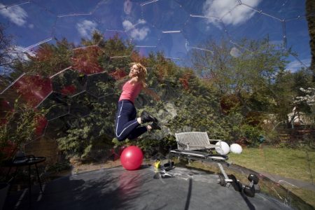 A woman jumping during a workout in a garden gym