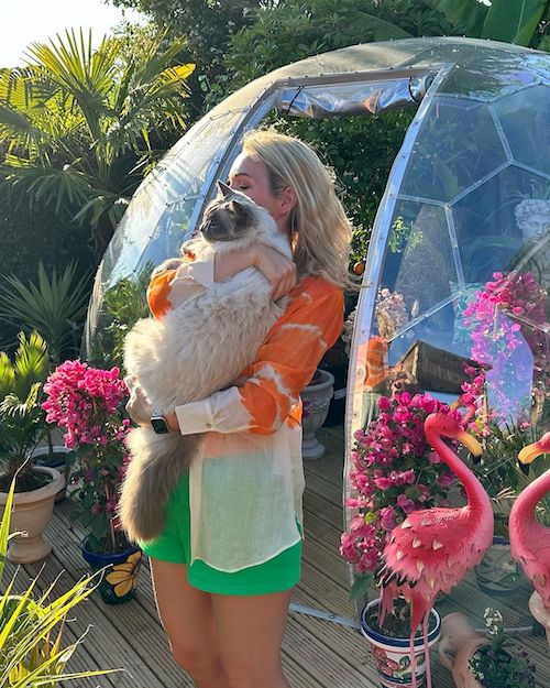 Une femme tenant un chat dans le jardin