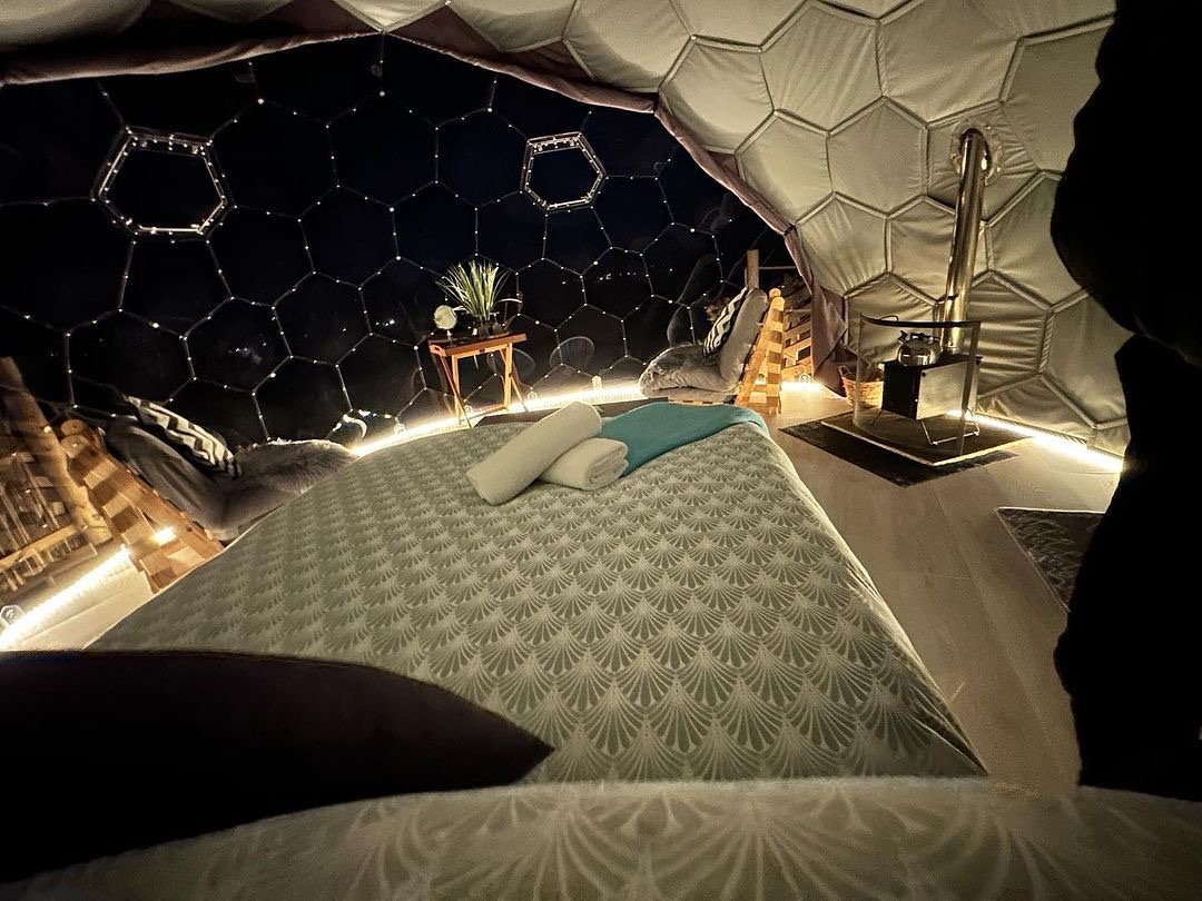 Gemütliche Glamping-Kapsel mit warmen Kissen und Decken