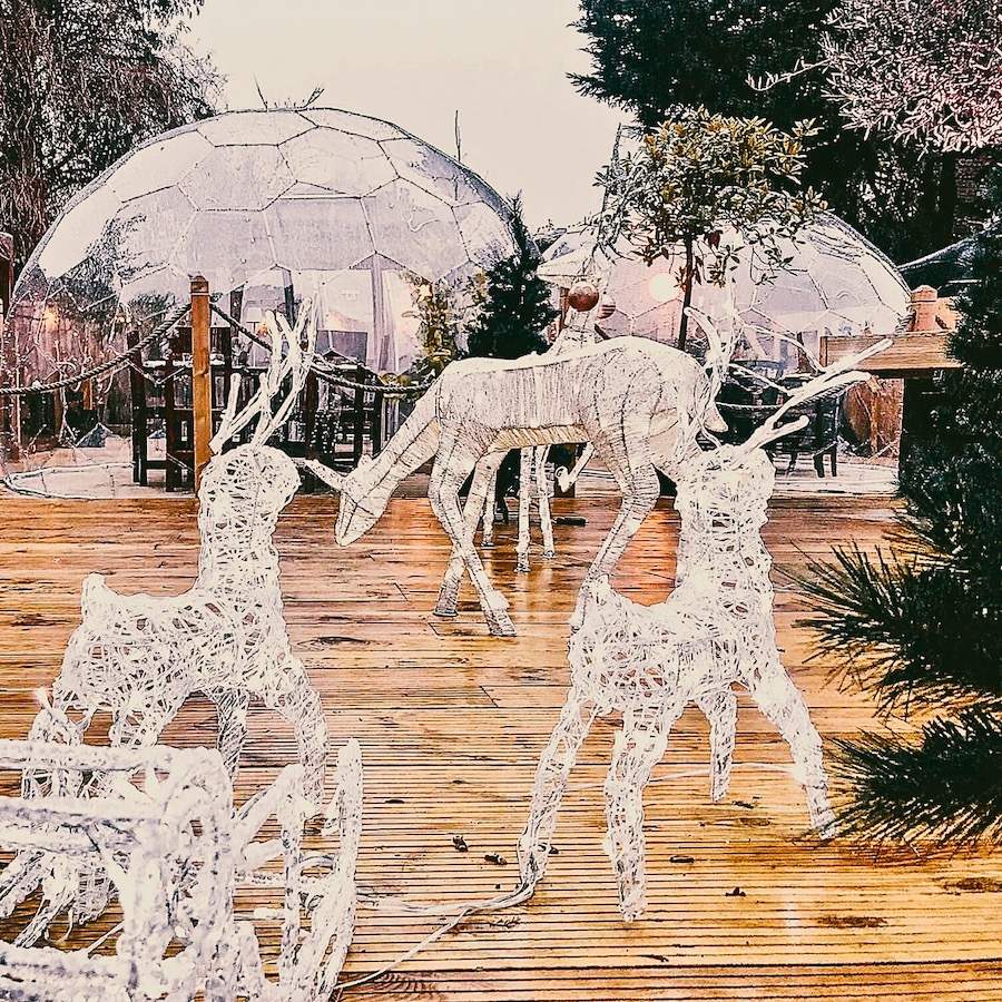 Salle à manger extérieure d'un restaurant, avec dôme de salle à manger et décorations lumineuses en forme de renne