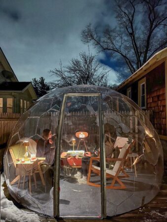 Women entertaining in a warm backyard dome in winter