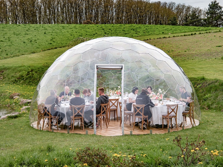 Des personnes dînent dans le grand dôme géodésique Hypedome L