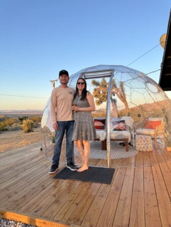 Shelly and her husband in front of their Airbnb dome