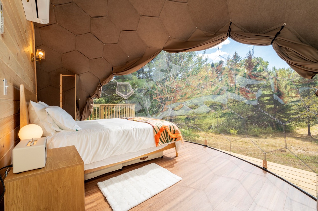 A view from a bay window from the inside of a glamping Nova Nook dome