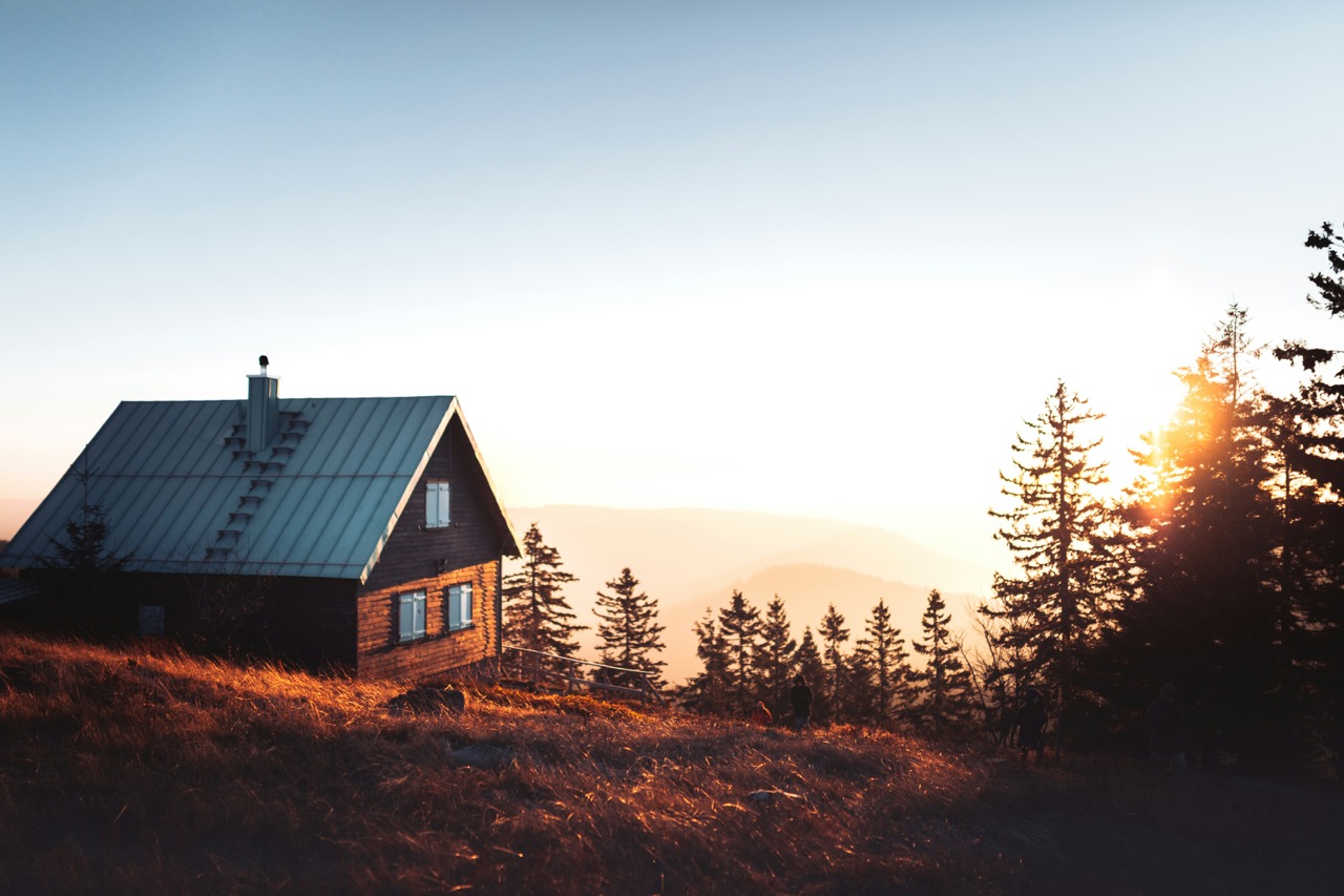Cabane à ossature en bois avec fenêtres éclairées et foyer dans une forêt d'automne