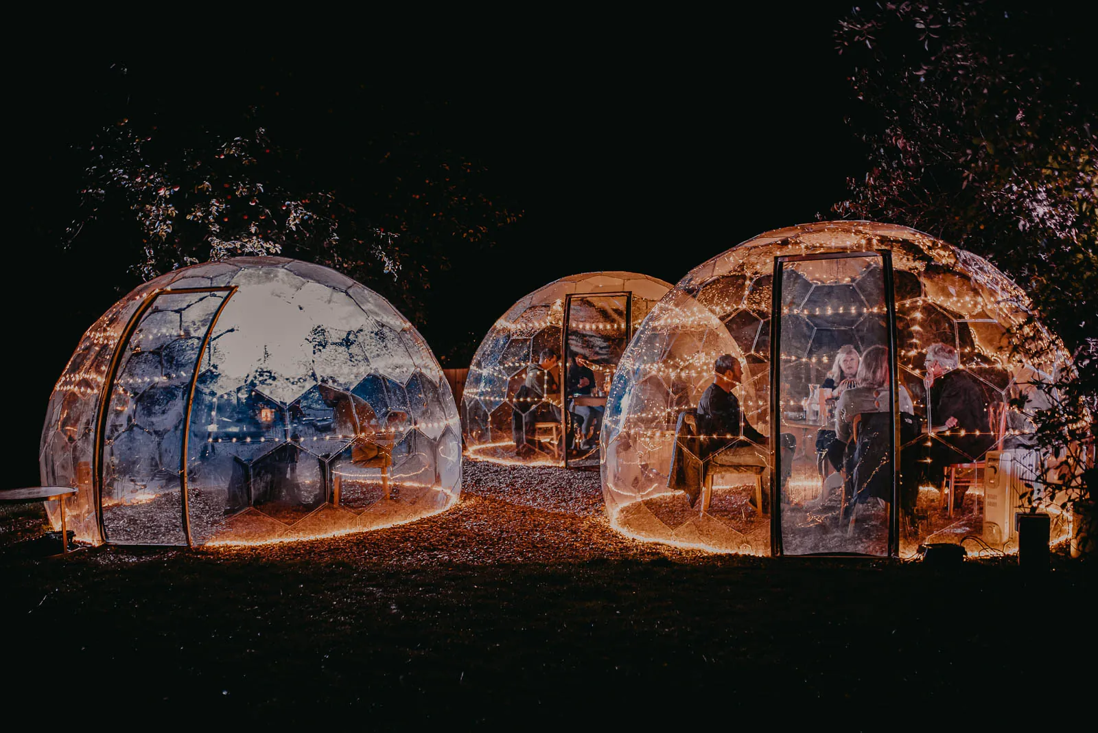 Illuminated domes with dining friends