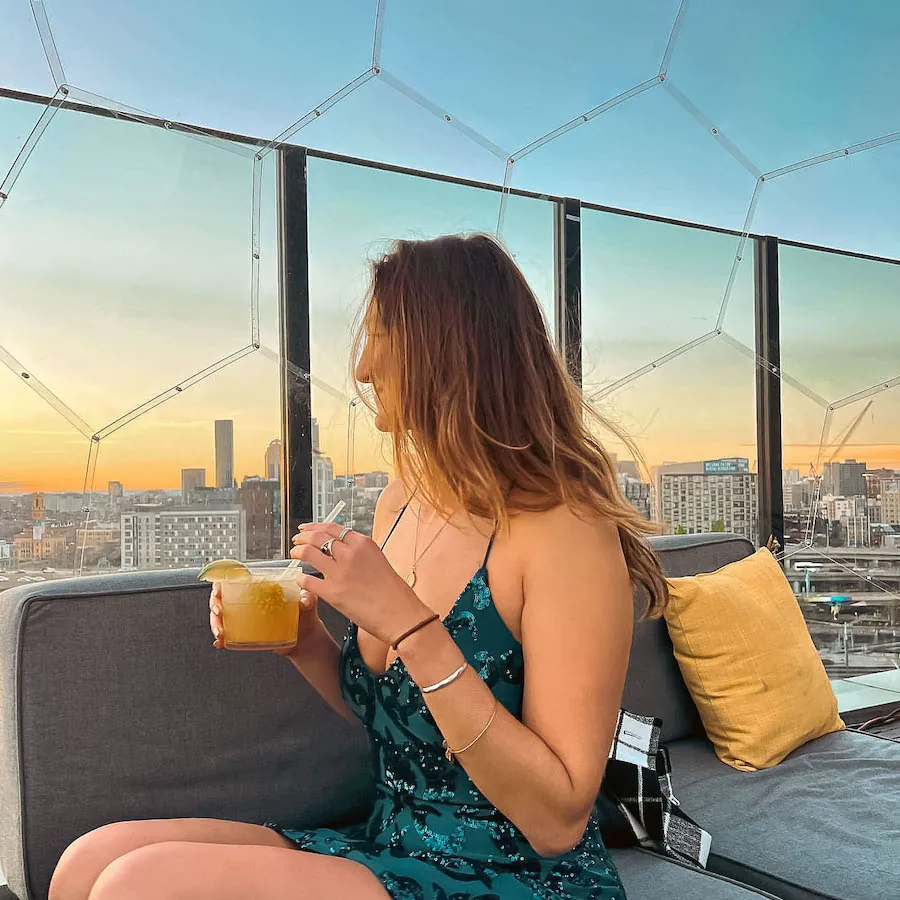 A woman sitting in a backyard pod with a beverage