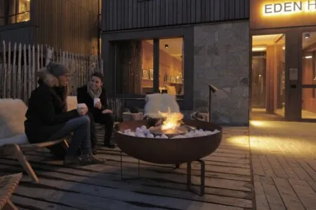 A fire pit and two women on a warm winter patio