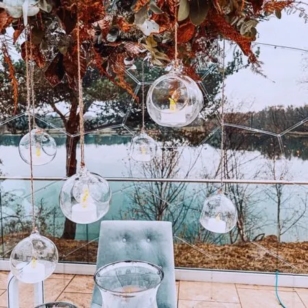 Glass bubbles with candles hanging from the top of the dining dome in a Christmas restaurant scenery