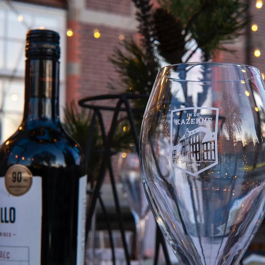 A glass and wine inside the dome dining experience in In De Kazerne