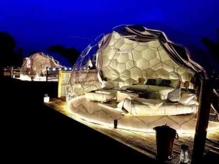 A beautifully illuminated glamping dome by night