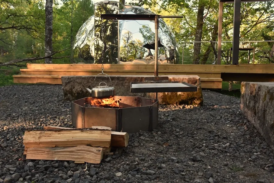 A fire pit placed next to the glamping dome