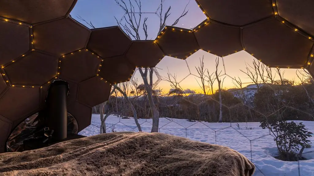 A cozy insulated geodesic dome surrounded by snow