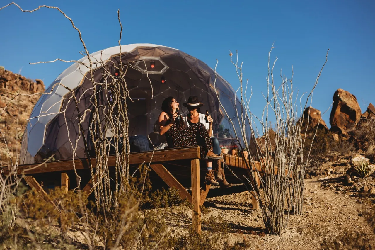 Two women hanging out in front of the glamping dome in the desert