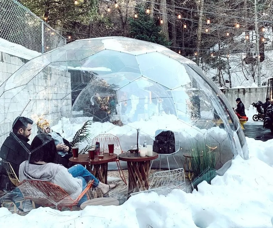 A cozy and warm interior of a winter dome in snowy outdoor spaces of a mountainous bar