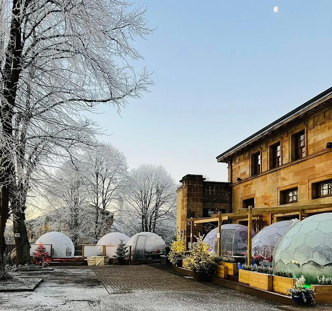 A restaurant in a mountainous landscape, with a set of outdoor apres-ski domes