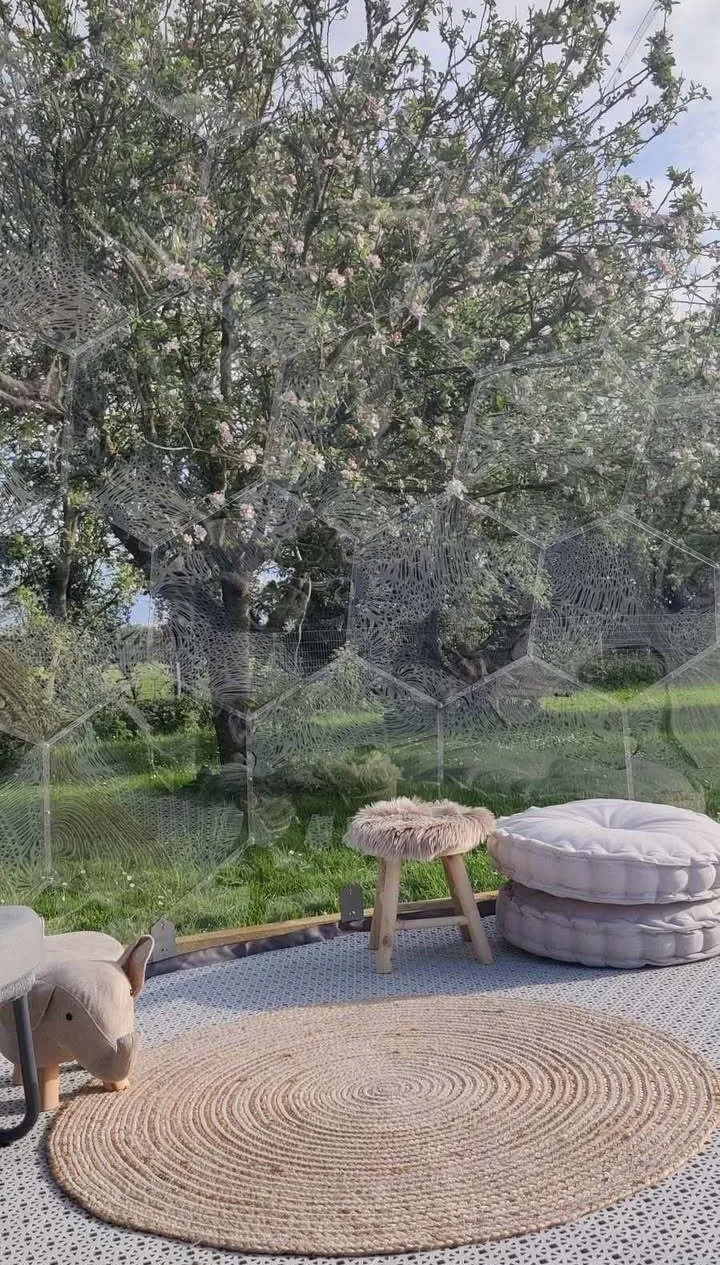 Furniture inside the garden dome in a windy orchard