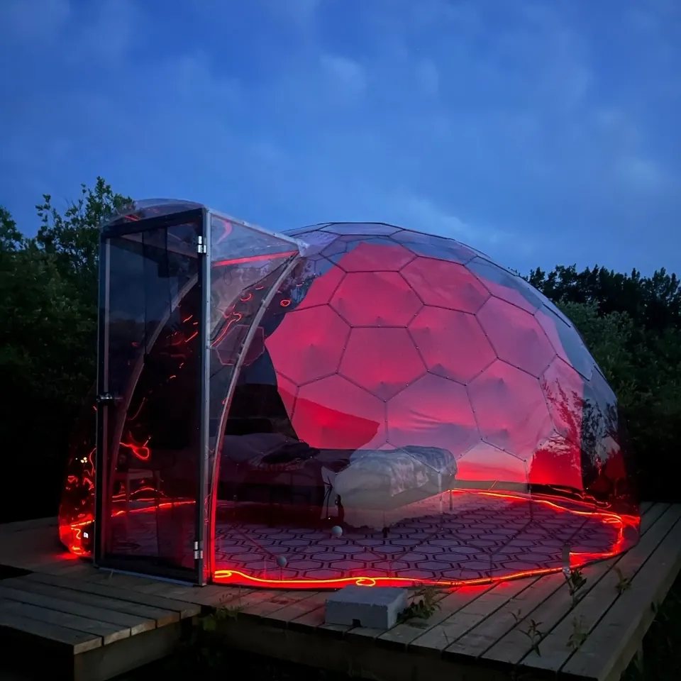Glamping dome by night, with red lights illumination
