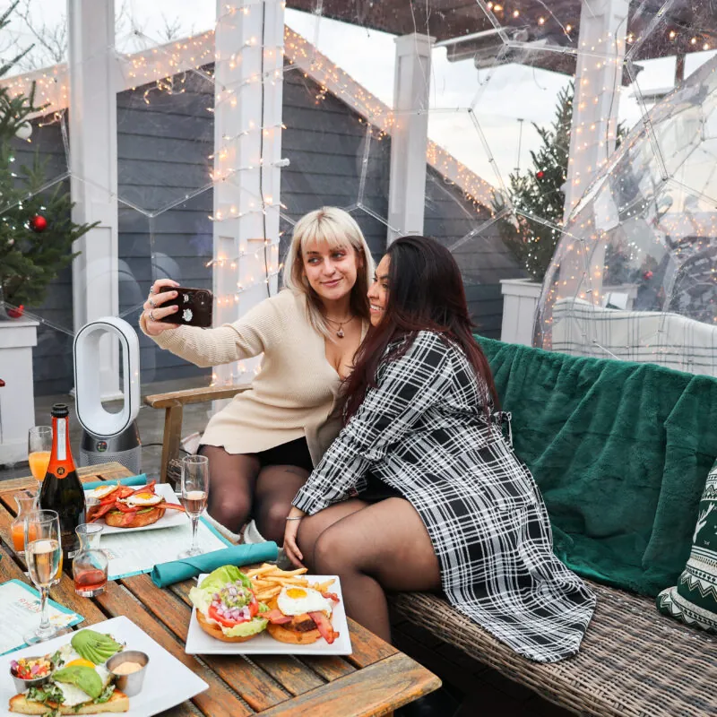 Two women taking selfie in a dining dome on Long Island