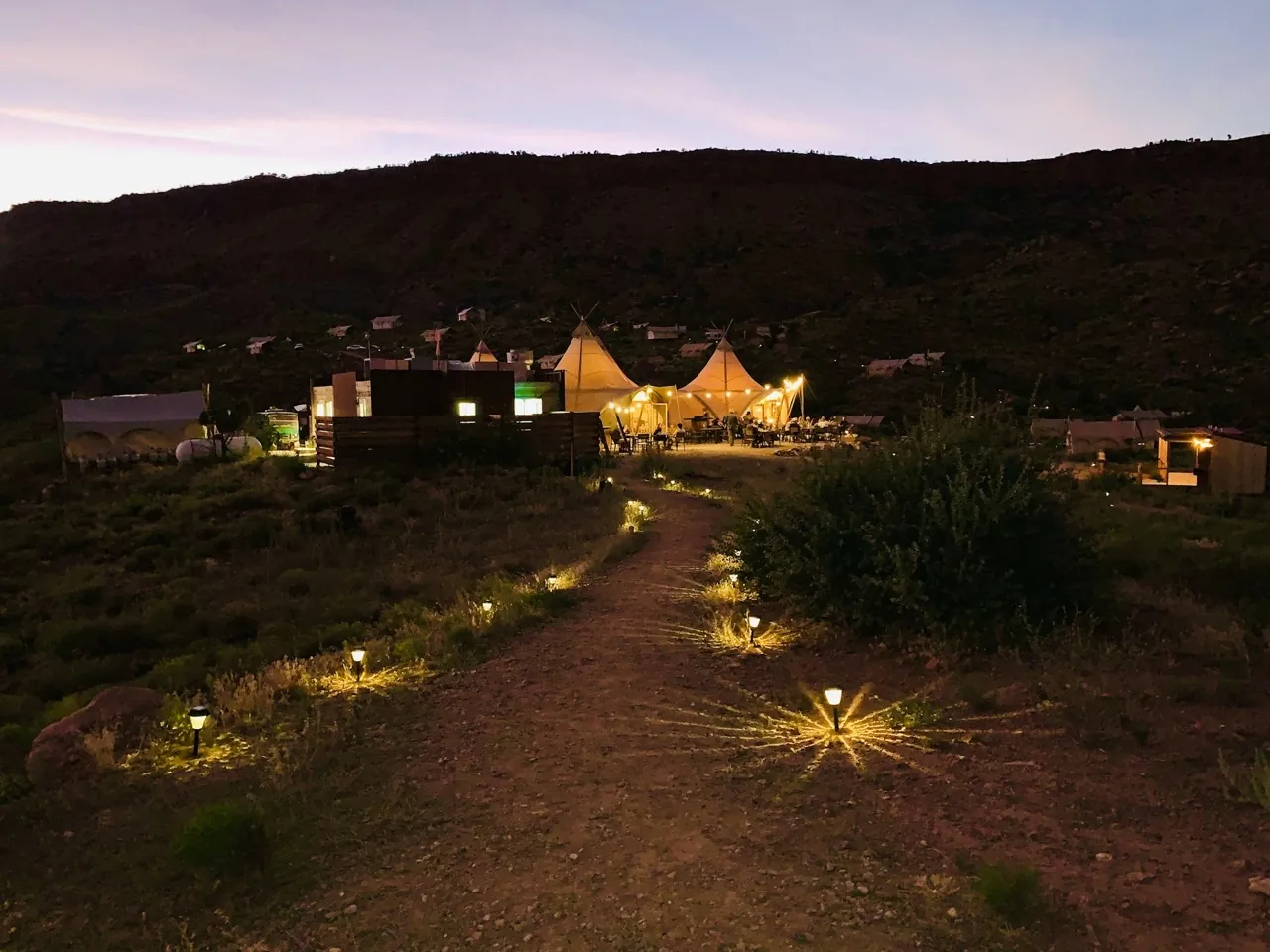A softly illuminated glamping site