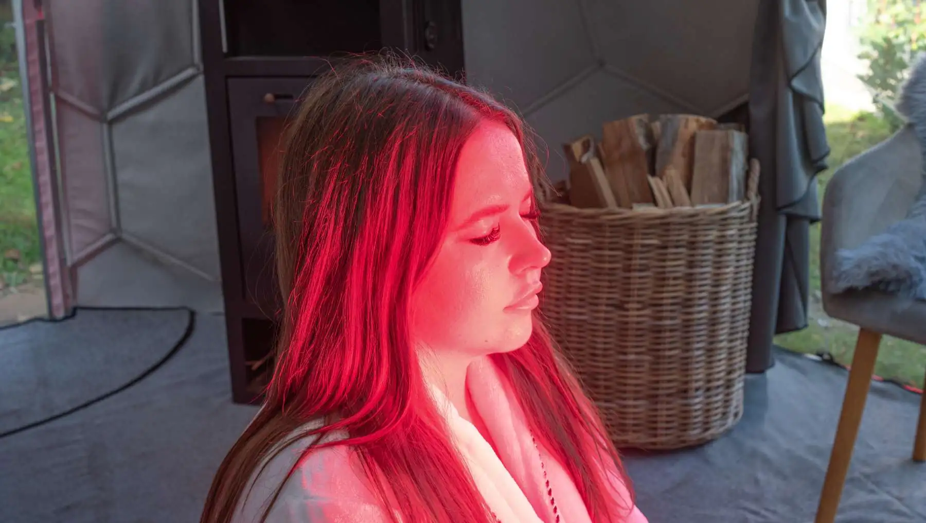 Woman relaxing in a Hypedome during a red light session as part of a longevity-focused backyard wellness retreat