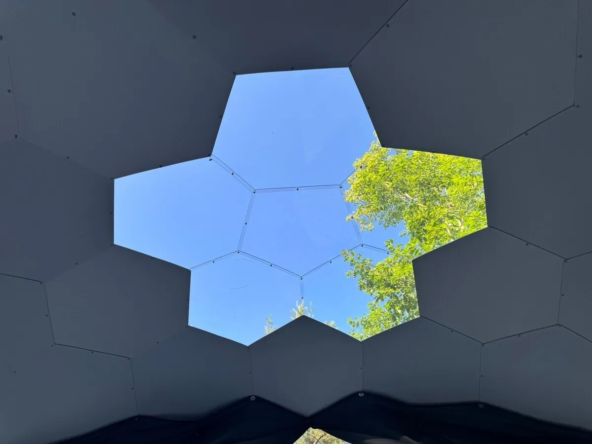 Dome-specific angle: interior view of clear skylight apex panels — an angle no four-walled rental can offer